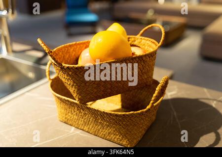 Due cesti di frutta impilati in rattan, con frutta fresca nel cesto superiore Foto Stock
