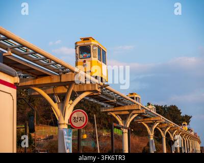 Busan, Busan, Corea del Sud - 14 febbraio 2026: Vista delle colorate auto Sky Capsule che si muovono lungo i binari elevati del treno di Haeundae Beach a Bl Foto Stock