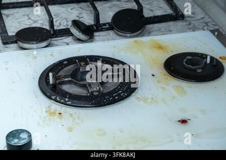 Piano cottura a gas bianco trattato con schiuma e detergente Foto Stock