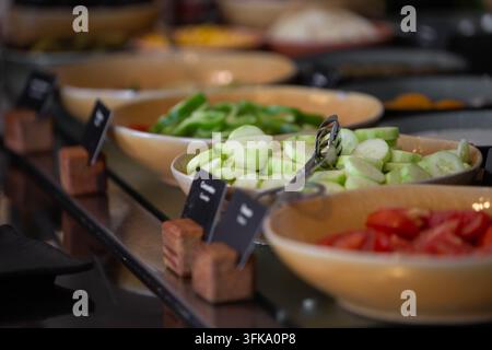 Bar di insalata di verdure fresche al buffet della colazione dell'hotel con cetrioli e pomodori affettati. Bar di insalata self-service salutare con cetrioli freschi affettati Foto Stock
