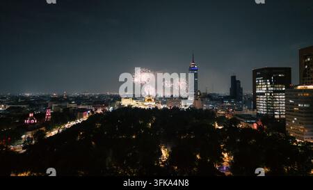 Vista aerea di fuochi d'artificio che illuminano il cielo notturno sopra l'Alameda Central e lo skyline illuminato della Città del Messico, Ciudad de Mexico, Ciudad de Mexic Foto Stock