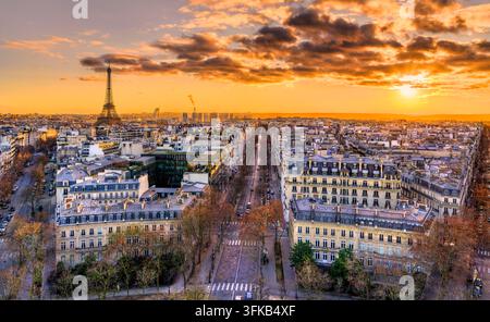Vista panoramica elevata sull'architettura di Parigi e sulla Torre Eiffel illuminata da un cielo dorato al tramonto. Foto Stock