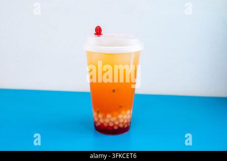 Tè ai frutti con perle di boba in un bicchiere di plastica. Bevanda tropicale rinfrescante con frutto della passione e palline di tapioca. Bevanda estiva per menu da asporto o caffè Foto Stock