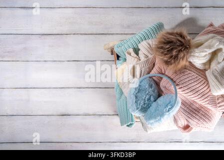 Preparazione per la stagione autunnale e invernale, abiti caldi e accoglienti in autunno, pila di giacche pulite appena lavate, ben ripiegate, maglioni, coperte, cappelli, m Foto Stock