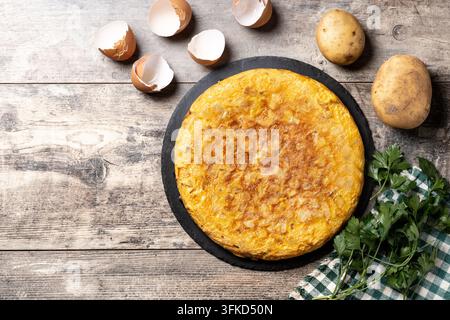 Frittata spagnola tradizionale e ingredienti su tavolo di legno Foto Stock