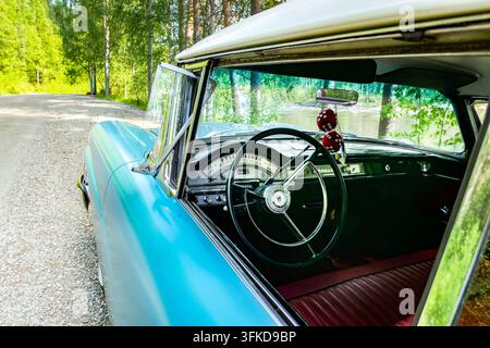 Interno di auto classica restaurato con volante originale, comandi e rivestimenti rossi Foto Stock