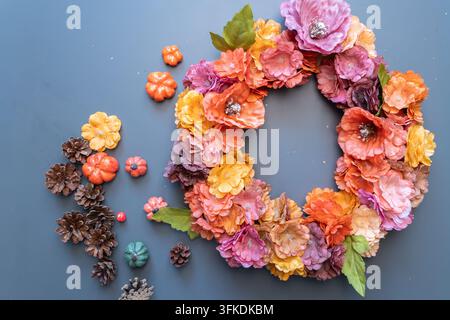 Ghirlanda floreale autunnale colorata finita con pigne e mini zucche Foto Stock