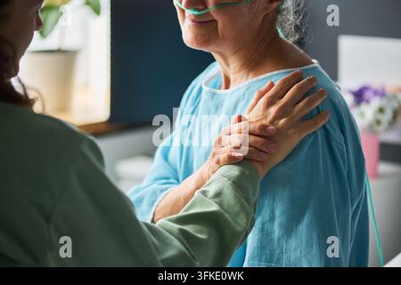 Donna premurosa che sostiene una paziente anziana in ospedale Foto Stock