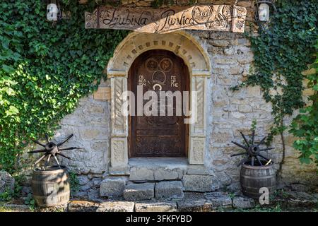 Ingresso a Ljubina Pivnica con un San Giorgio intagliato che uccide i barili drago, Cantina Radosavijevic, villaggio di Rogijevo, Serbia Foto Stock