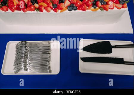 Torta di frutta e utensili da servizio a una celebrazione Foto Stock