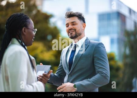 Diverse persone di affari che networkano all'aperto discutendo di strategia aziendale Foto Stock