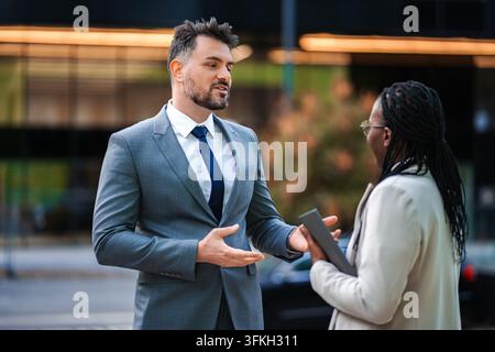 Colleghi di affari che parlano, discutono di strategia durante un incontro all'aperto Foto Stock
