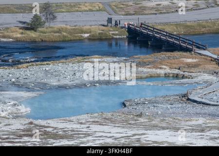 Una vista di un ponte e di un fiume accanto a una sorgente termale nello Yellowstone National Park, Wyoming. Foto Stock