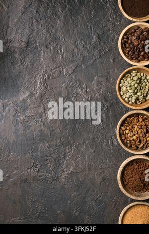 Varietà di messa a terra, il caffè istantaneo, diversi chicchi di caffè, zucchero di canna in ciotole di legno in fila più scuro dello sfondo texture. Vista superiore, spazio Foto Stock