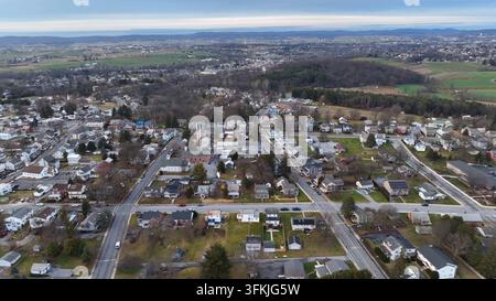 Città americana vista dall’alto in una giornata invernale negli USA. Vista aerea dall’alto. Area rurale con foresta e colline sullo sfondo, Akron, Pennsylvania. Foto Stock
