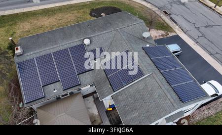 Unità fotovoltaiche sul tetto di una casa in un piccolo villaggio americano durante il giorno. Ripresa aerea dall'alto in cerchio. Vecchie strade distrutte nella città di Akron, Pennsylvania Foto Stock