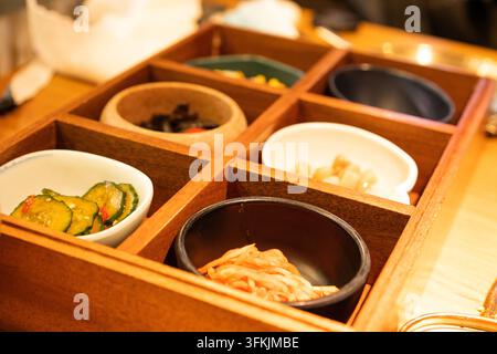 Prima vista di un vassoio banchan in legno con sei scomparti in un ristorante coreano Foto Stock