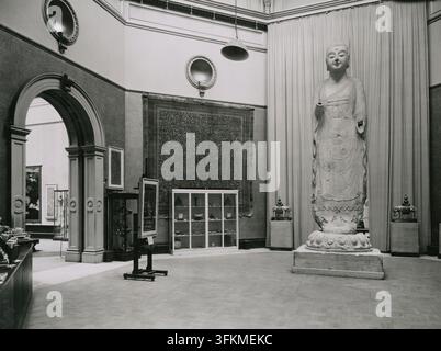 Viste della galleria della 'Esposizione Internazionale d'Arte Cinese' tenutasi alla Royal Academy of Arts, Burlington House, Londra da novembre 1935 a marzo 1936 (1935). Sala centrale, vista dal centro della galleria con l'ingresso alla Galleria IX a sinistra, il Buddha Amitabha (numero di catalogo 2360) a destra, una coppia di elefanti smaltati 'cloisonné' (numeri di catalogo 2317 e 2318) su entrambi i lati del Buddha, e, appeso al muro, un tappeto di lana (numero di catalogo 2313). Foto Stock