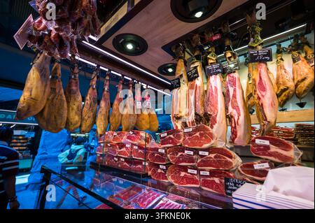 Prosciutto spagnolo appeso e carne di maiale confezionata al mercato in Spagna Foto Stock