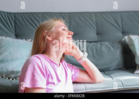 Donna stanca con gli occhi chiusi che prova dolore alla testa, ideale per la pubblicità nel settore sanitario, neurologia e farmaci antidolorifici. Foto Stock