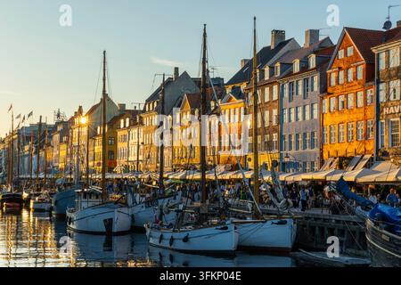Barche davanti a case dai tetti colorati a Nyhavn, Copenaghen, Danimarca Foto Stock
