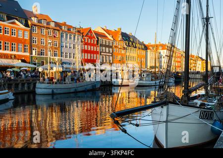Barche davanti a case dai tetti colorati a Nyhavn, Copenaghen, Danimarca Foto Stock