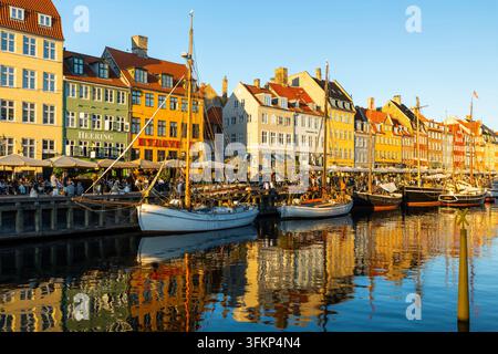 Barche davanti a case dai tetti colorati a Nyhavn, Copenaghen, Danimarca Foto Stock