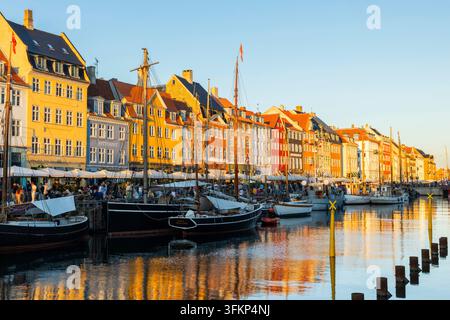 Barche davanti a case dai tetti colorati a Nyhavn, Copenaghen, Danimarca Foto Stock