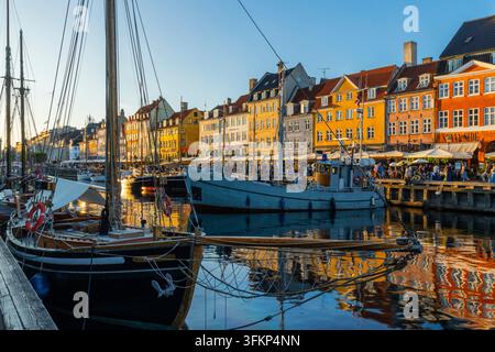 Barche davanti a case dai tetti colorati a Nyhavn, Copenaghen, Danimarca Foto Stock
