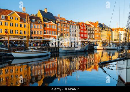 Barche davanti a case dai tetti colorati a Nyhavn, Copenaghen, Danimarca Foto Stock