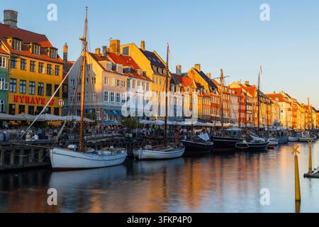 Barche davanti a case dai tetti colorati a Nyhavn, Copenaghen, Danimarca Foto Stock
