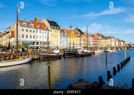 Barche davanti a case dai tetti colorati a Nyhavn, Copenaghen, Danimarca Foto Stock