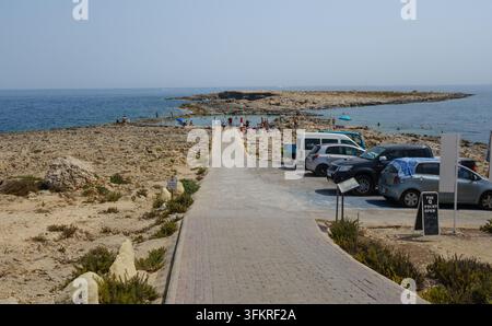Una vista sul mare verso la piscina di Qawra e la spiaggia di Ta Fra a St Pauls Bay Malta che mostra affioramenti di calcare usati nella Seconda Guerra Mondiale come ausilio per l'addestramento aereo. Foto Stock