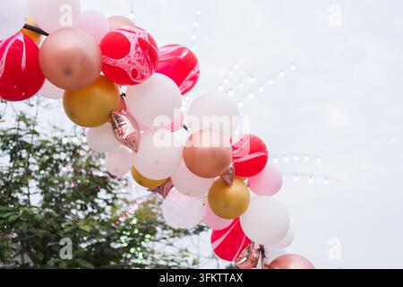Decorazione ad arco di palloncini colorati all'aperto con sfondo di alberi e cielo Foto Stock