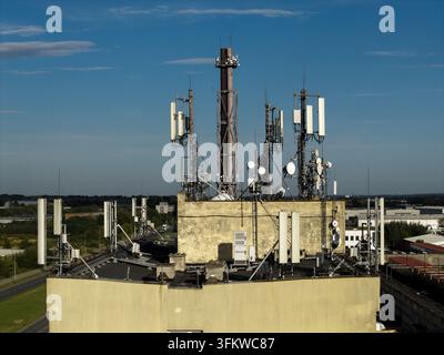 Vista aerea di antenne di telecomunicazioni e di un camino montati su un tetto a Cracovia, Voivodato della Piccola Polonia, Polonia. Foto Stock