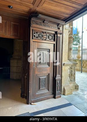 Porta in legno antica ornata con iscrizione latina e pannelli intagliati. Una porta in legno antica finemente intagliata con pannelli rialzati, ar classica Foto Stock