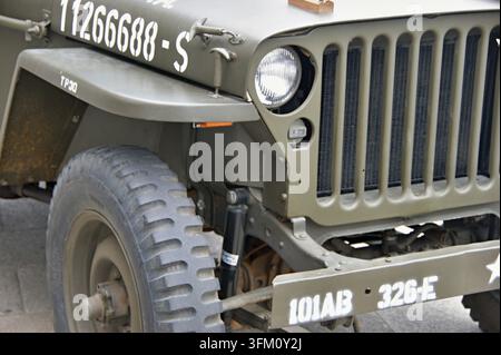 Veicolo militare Willys Jeep in primo piano che mostra la griglia anteriore, i fari, le gomme e le marcature Foto Stock