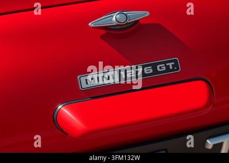 Emblema Mini 1276 GT e maniglia della porta su una carrozzeria rossa vintage Foto Stock