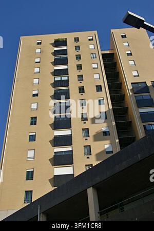 Facciata di un edificio residenziale con molte finestre, balconi e un cielo blu terso Foto Stock