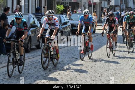 I ciclisti percorrono una strada di ciottoli durante una competizione Foto Stock