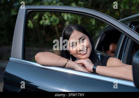 Giovane donna asiatica in un'auto Foto Stock
