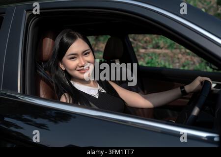 Felice giovane donna in auto Foto Stock