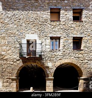 Un antico edificio in pietra con diverse finestre e un piccolo balcone, atmosfera rustica, Maestrazgo (Maestrat, Alto Maestrazgo, l'Alt Maestrat), Mos in Spagna Foto Stock