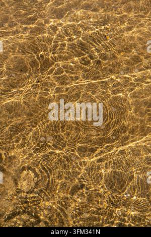 Questa fotografia affascinante mostra i motivi ipnotizzanti creati dalla luce del sole che si riflette su uno specchio d'acqua, rivelando una danza intricata di luce Foto Stock