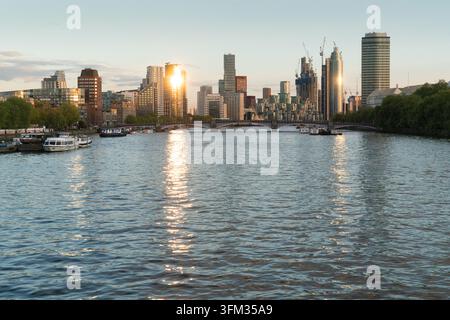 Il tramonto si riflette sulla skyline di Vauxhall e Albert Embankment di Londra, illuminando torri moderni e il Tamigi con una luce dorata. Foto Stock