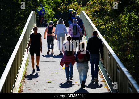 Duisburg, Germania. 27 set., 2026. Passeggiatrici passeggiano su un ponte alla Sechs-Seen-Platte sotto il sole. Credit: Christoph Reichwein/dpa/Alamy Live News Foto Stock