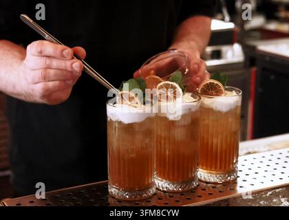 Mano di barista che lavora con un set da cocktail per guarnire una bevanda Foto Stock