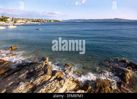 Selce, costa rocciosa, vista su Krk Foto Stock