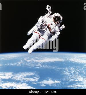 Una fotografia della NASA che ritrae l'astronauta statunitense Bruce McCandless II (1937–2017) durante la missione STS-41-B mentre eseguiva la prima attività extraveicolare senza legami della storia. Utilizzando l'Manned Maneuvering Unit (MMU), uno zaino azionato a azoto e controllato manualmente, McCandless ha raggiunto una completa indipendenza dallo Space Shuttle Challenger, consentendo una mobilità senza precedenti nel vuoto dello spazio mentre orbitava sopra la Terra. Questa missione ha dimostrato la fattibilità tecnica della MMU per il recupero di satelliti e le operazioni di riparazione orbitale. 1984. Foto Stock