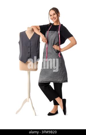 Azienda di design della moda e sartoria, sarta sorridente con metro a nastro in piedi accanto a un manichino che indossa un gilet su sfondo bianco Foto Stock